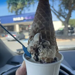 a hand holding a cup of ice cream