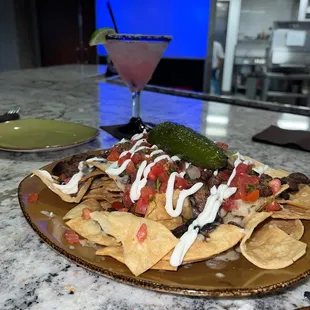 a plate of nachos and a drink