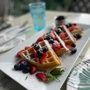Waffles with strawberries, blueberries, &amp; sprinkled with powdered sugar
