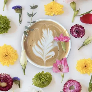 a cup of coffee surrounded by flowers