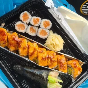 a person holding a tray of sushi