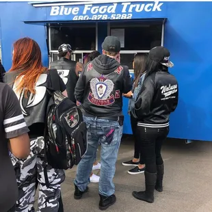 a group of people standing in front of a food truck
