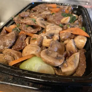 a tray of stir fried mushrooms and carrots