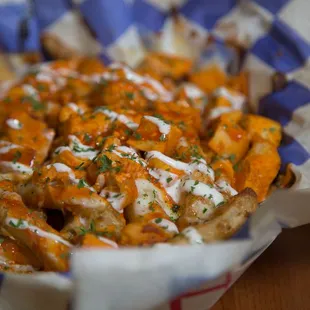 a basket of fries covered in sauce