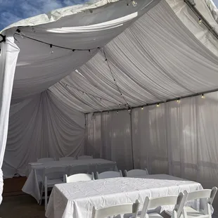 10x20 tent with white drapes, 6 feet tables, and resin chairs