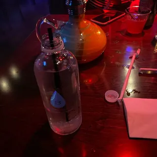 a glass of water and a notepad on a wooden table