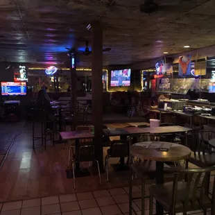 tables and chairs in a dimly lit bar