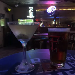 a martini and a beer on a table