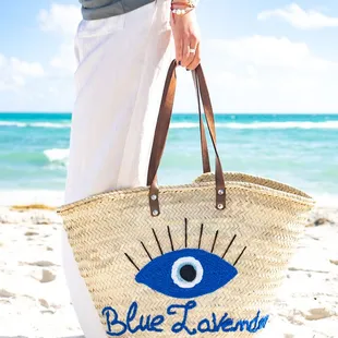 a woman carrying a blue lavender bag on the beach