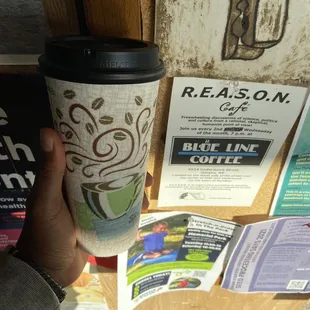 Hot cider in front of their cork board signs and ads