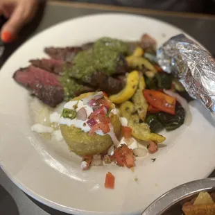 a plate of steak, potatoes, and vegetables