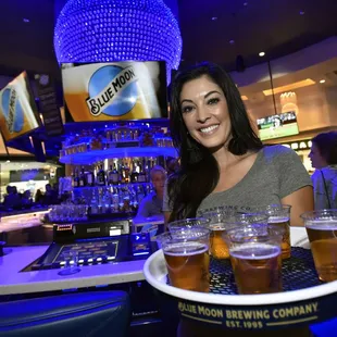 a woman holding a tray of beer