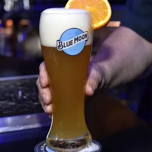 a person holding a glass of beer