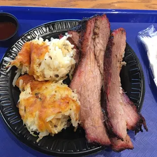 a plate of bacon, potatoes, and hash browns