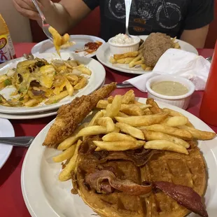 Front: chicken and waffles  Middle: Philly steak nacho fries  Farthest away: Cajun catfish