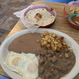 Huevos rancheros sauce on side, tender guisada, tasty papas, and tortillas from heaven!