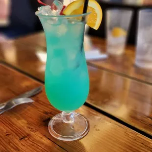 a blue drink with an umbrella