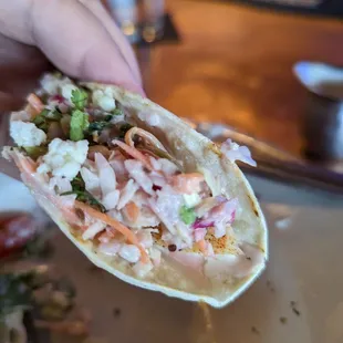 a hand holding a taco