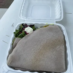 a sandwich and salad in a styrofoam container