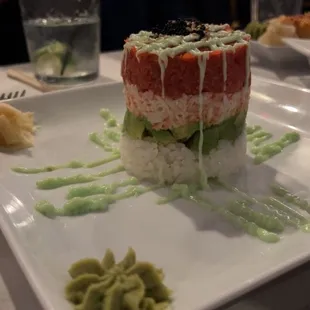 a plate of sushi with green sauce