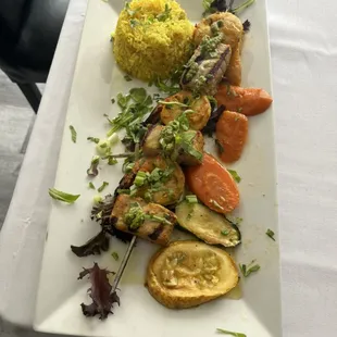 Grilled salmon and prawn kebab skewer, with saffron rice and medley of vegetables.