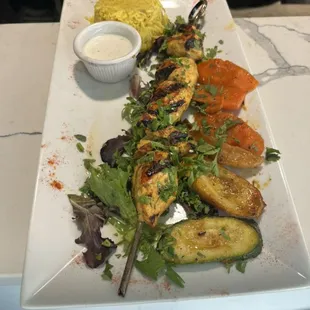 Chicken kebab with saffron rice and medley of grilled vegetables.