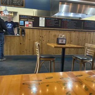 Counterman and a customer at Blue Ox Sandwich Factory.  Menu on the black board as you enter.