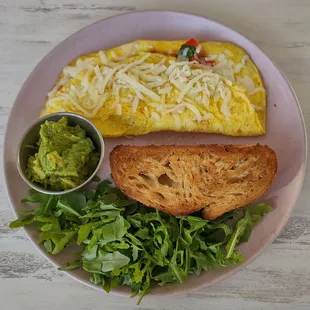 Veggie Omelette with toasted sourdough, mashed avocado, and arugula