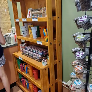 a woman standing in front of a shelf of cupcakes