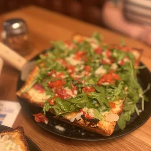 a slice of pizza on a black plate