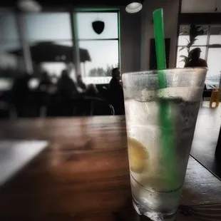 a glass of lemonade with a green straw