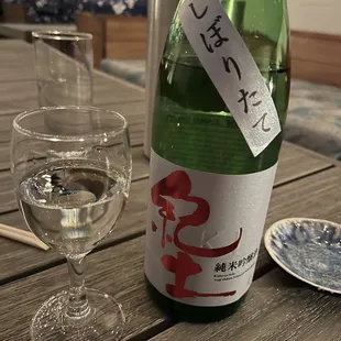 a glass of water and a bottle of sake