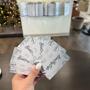 a hand holding four business cards