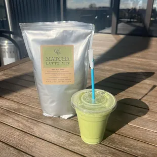 a bag of matcha latte next to a cup of matcha latte