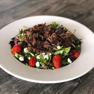 a salad with beef and strawberries