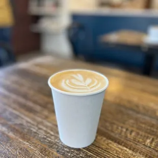 a cup of coffee on a wooden table