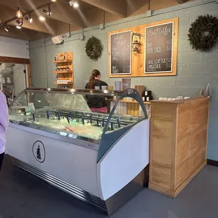 a woman standing in front of a deli counter