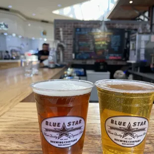 two glasses of beer on a bar