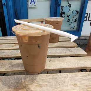 two cups of iced coffee on a wooden table