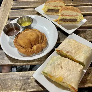 Biscuit Egg Sausage Tomato (BEST) sandwich ($12), fried saltfish pocket ($6) and breakfast burrito ($12)