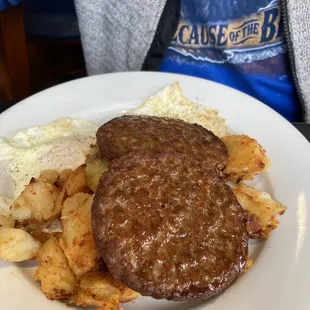 Sausage patty with eggs over easy and home fries