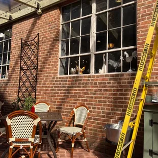 a brick patio with chairs and a ladder