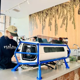 a woman working on a coffee machine