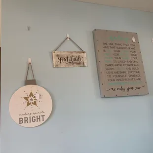 a blue wall with a sign and a sign hanging on it