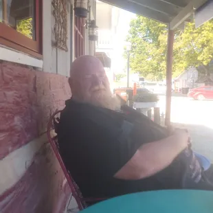 My husband  sitting  on their  porch