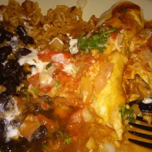 Half-eaten chicken and cheese enchilada with a side of black beans and Mexican rice ($7.75)