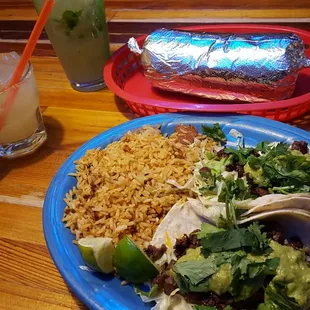 Carne asada tacos and a salmon burrito with a margarita and mojito.