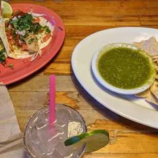 Chips and salsa Verde with two tacos -- one Al pastor and one tilapia