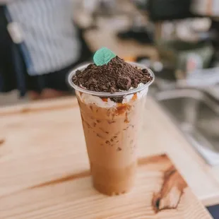 a cup of iced coffee on a wooden table