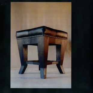 The design of this pouffe was inspired by the cubism art movement.
Each leg is made of a single piece of solid wood. Upholstered with black